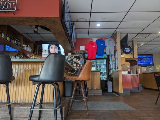 The bar, stools, and televisions inside The Choo-Choo